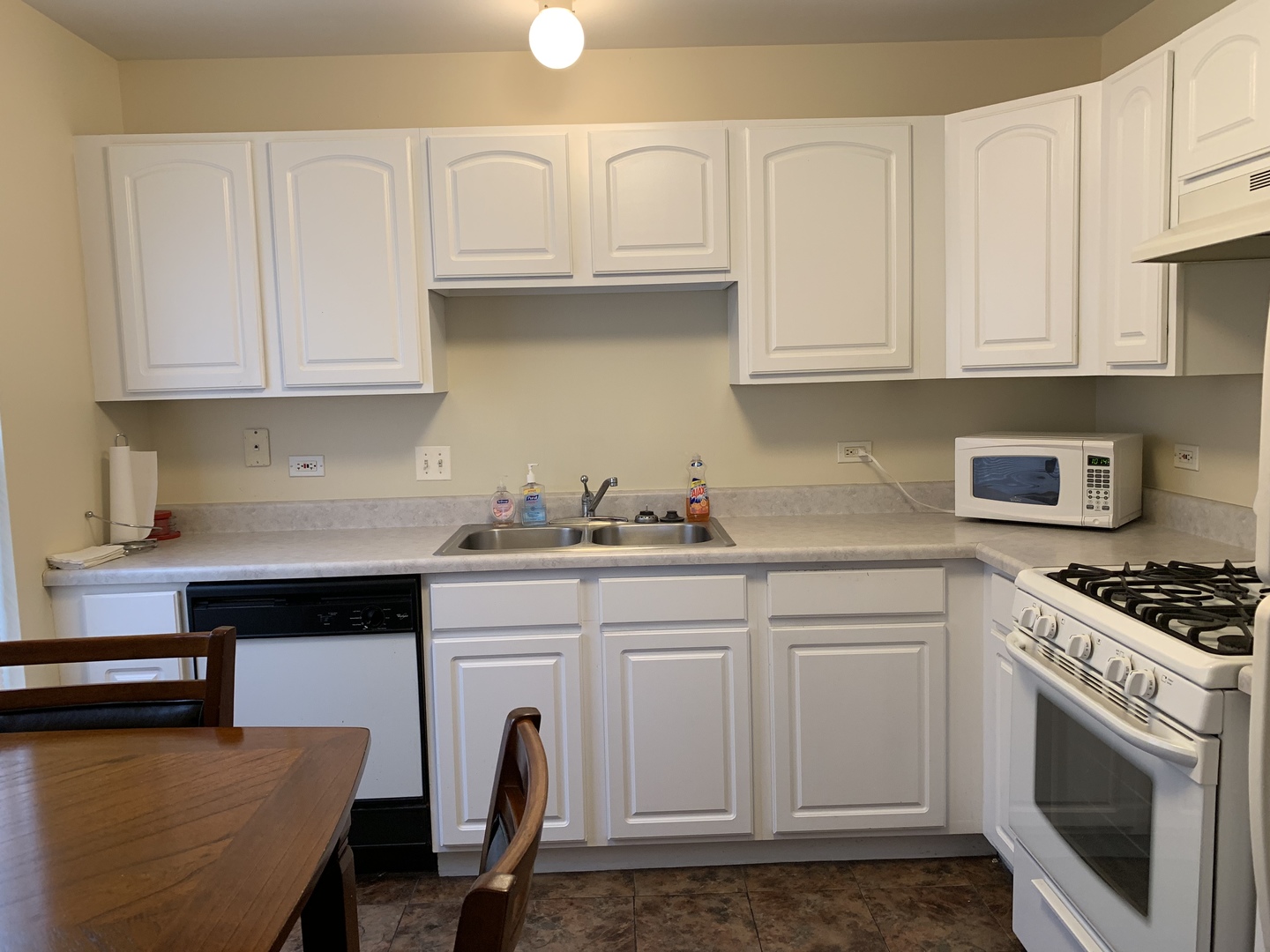 2927 Rutland Circle, Unit 101 Naperville, IL 60564 - Photo 5 of 11 a kitchen with granite countertop white cabinets and white appliances