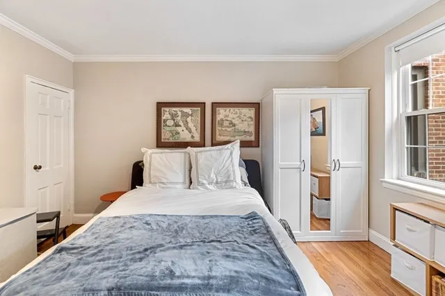 a large bedroom with a bed and wooden floor