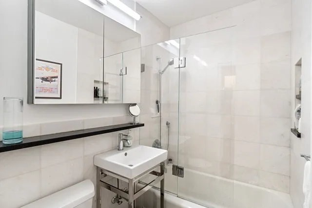 a bathroom with a sink a toilet and shower