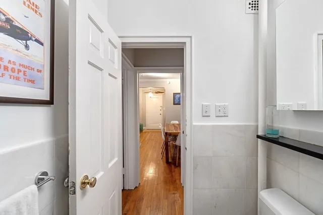 a view of a hallway with bathroom and wooden floor