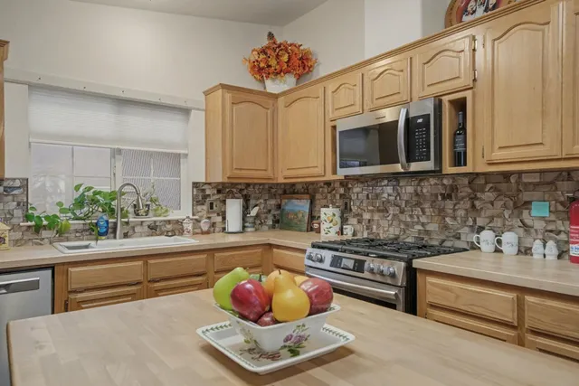 a kitchen with stainless steel appliances granite countertop a refrigerator and a sink