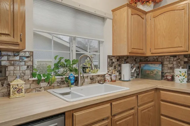 a kitchen with granite countertop a sink stove and cabinets