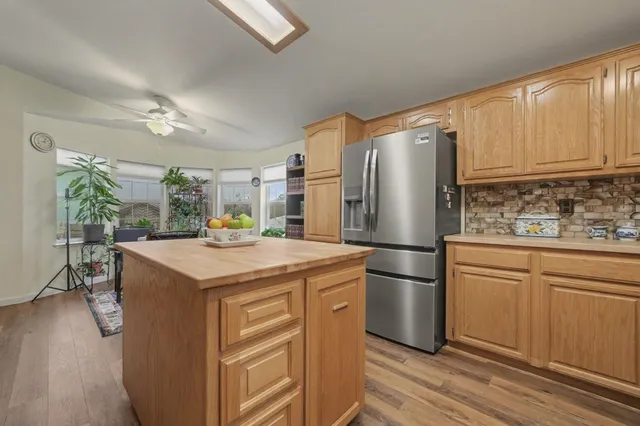 a kitchen with stainless steel appliances granite countertop a sink a refrigerator and a stove