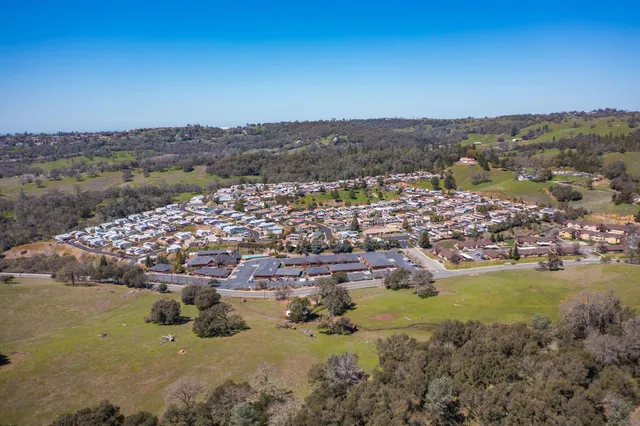 an aerial view of a house with balcony and outdoor seating