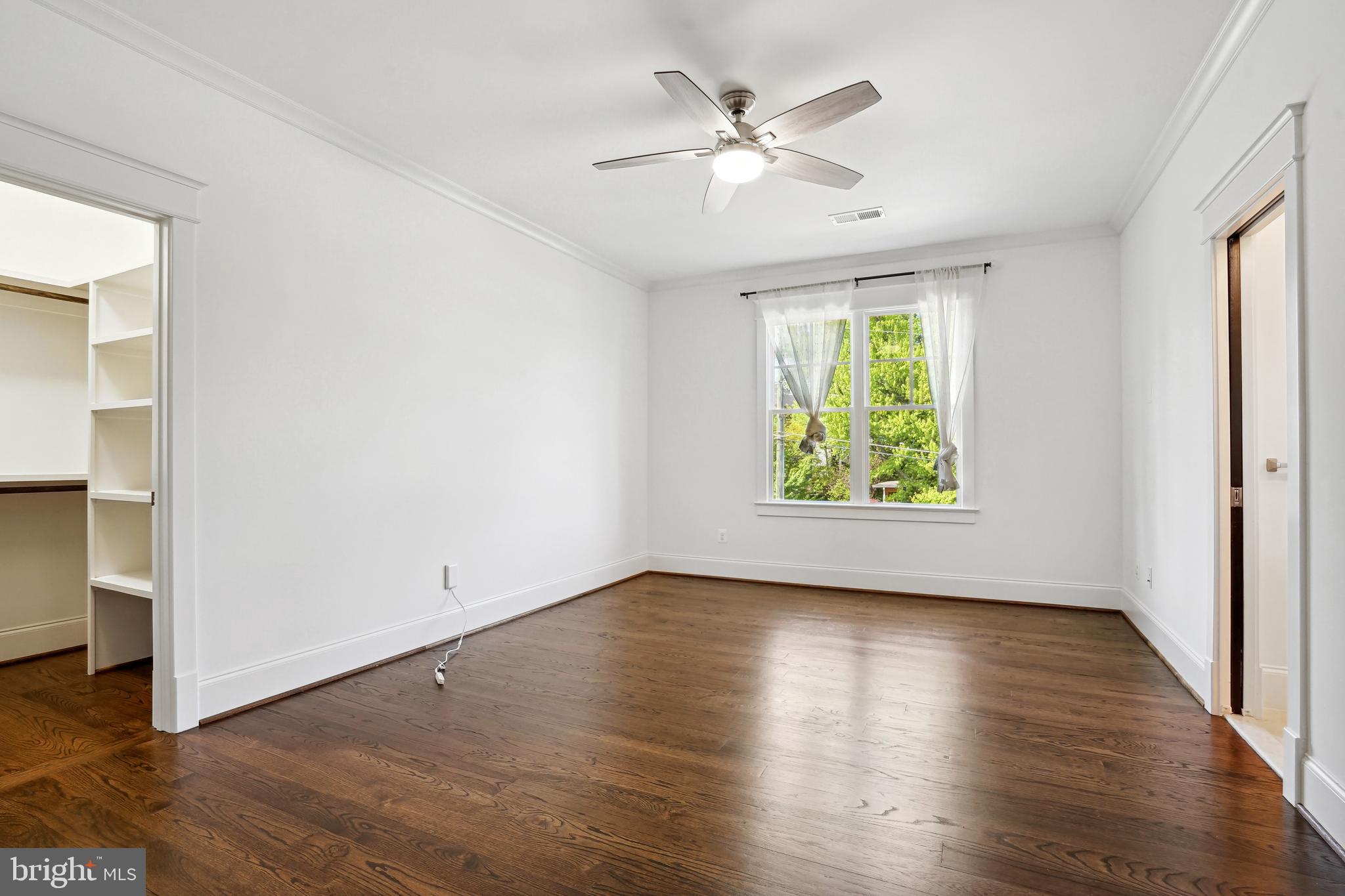 6719 Van Fleet Drive McLean, VA 22101 - Photo 6 of 29 an empty room with wooden floor chandelier fan and windows
