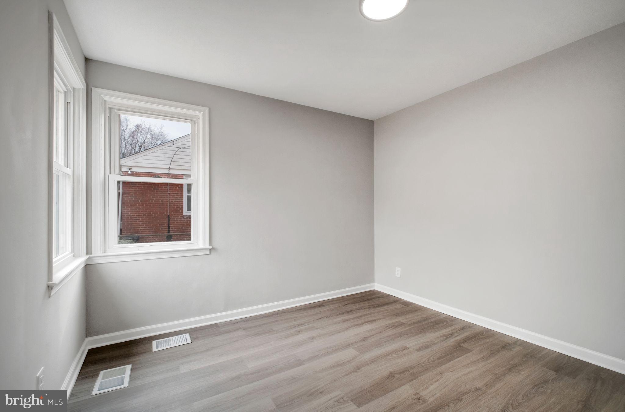 4829 Gilray Drive Baltimore, MD 21214 - Photo 11 of 28 a view of an empty room with wooden floor and a window