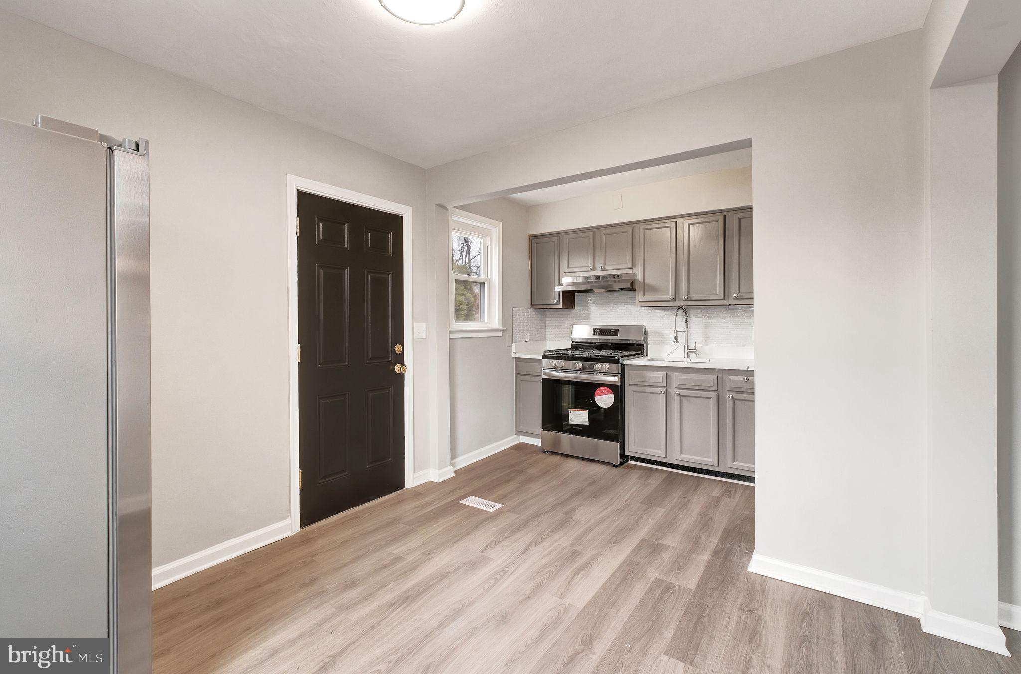 4829 Gilray Drive Baltimore, MD 21214 - Photo 5 of 28 a kitchen with a refrigerator and a stove top oven