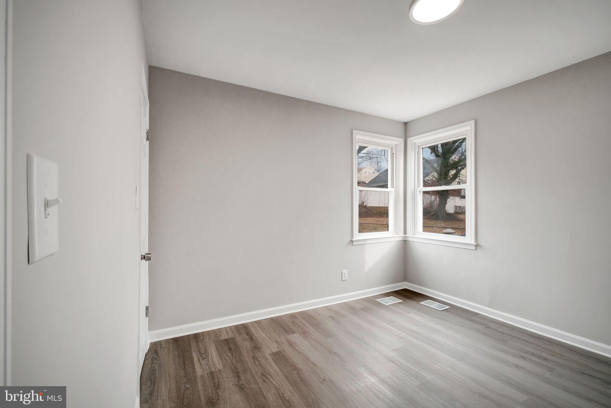 4829 Gilray Drive Baltimore, MD 21214 - Photo 10 of 28 an empty room with wooden floor and windows