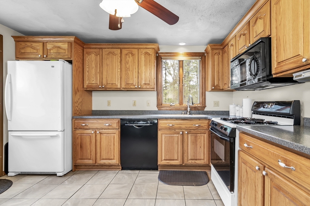 8 Portsmouth Road Amesbury, MA 01913 - Photo 14 of 37 a kitchen with stainless steel appliances granite countertop a refrigerator sink and stove