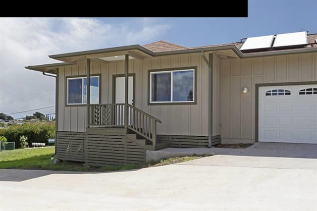 a view of a house with a small yard and wooden fence