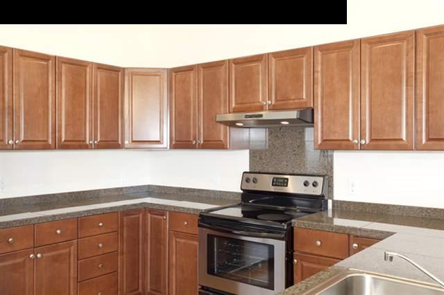 15 Maha Road, Unit 12 Makawao, HI 96768 - Photo 2 of 10 a kitchen with granite countertop a stove top oven cabinetry a sink and dishwasher