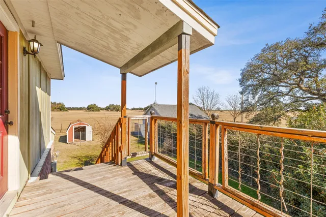 a view of a balcony with a floor to ceiling window with wooden floor