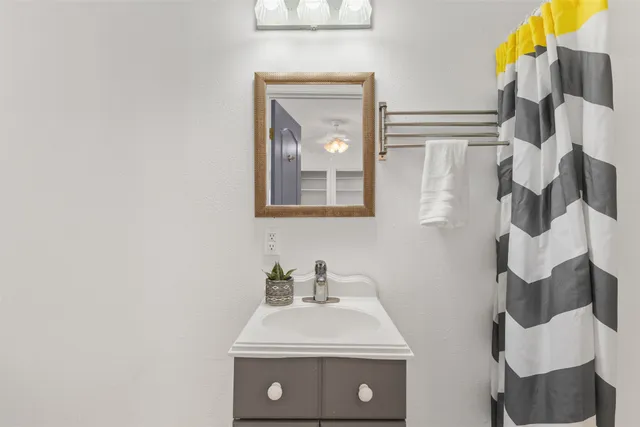 a bathroom with a sink and mirror with toilet