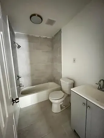 a white toilet sitting next to a bath tub