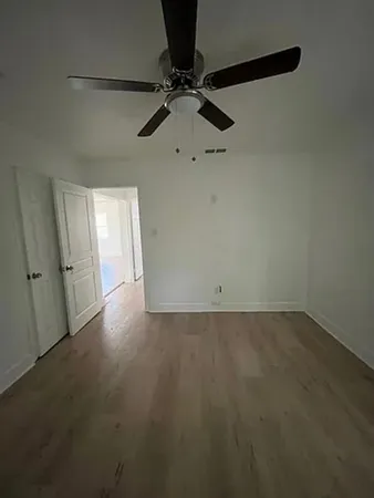 a view of a room with a ceiling fan and carpet