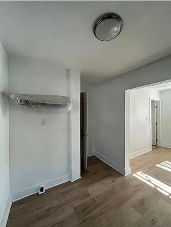 a view of a room with wooden floor and a window