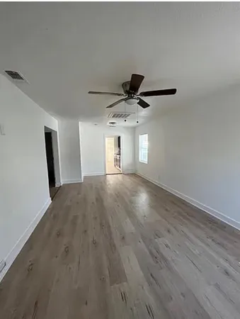 a view of a livingroom with wooden floor and a ceiling fan