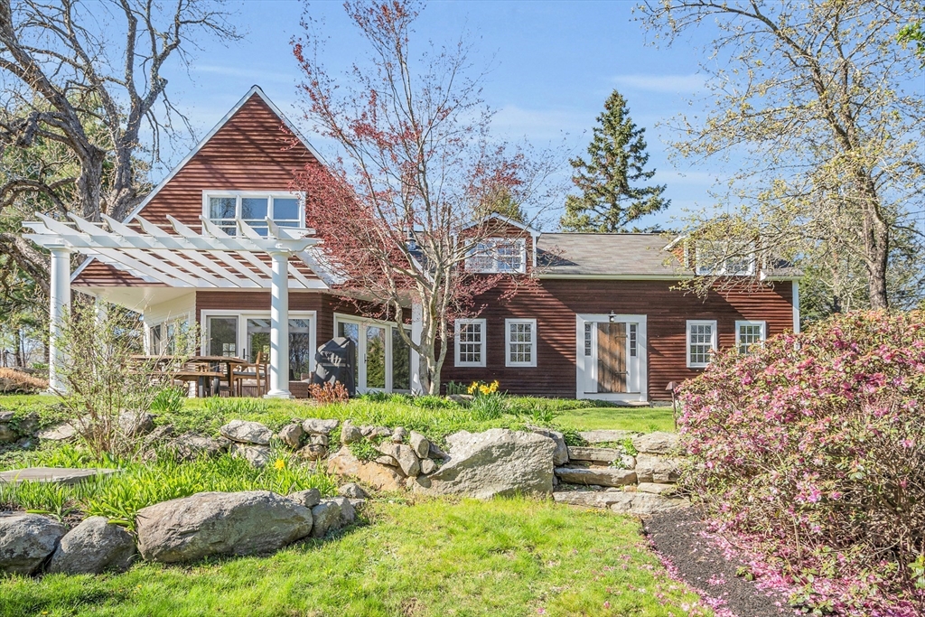 58 East End Road Bolton, MA 01740 - Photo 1 of 42 a front view of a house with a garden and trees