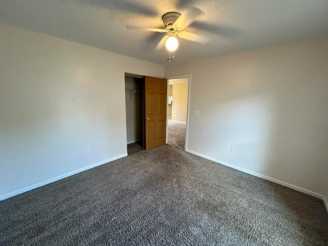 an empty room with a ceiling fan and a window