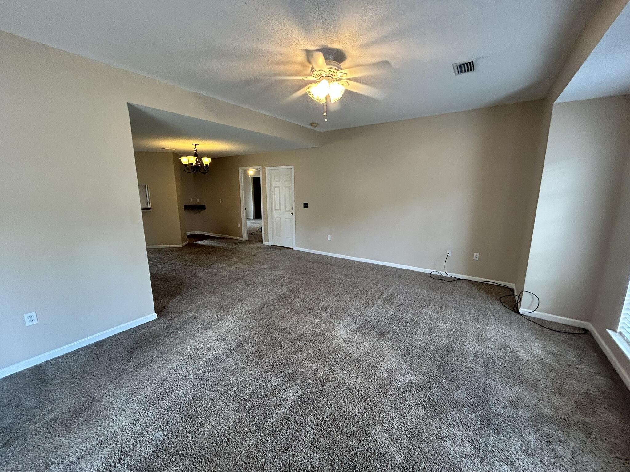 2175 Hagood Loop Crestview, FL 32536 - Photo 2 of 15 an empty room with a chandelier fan and a window