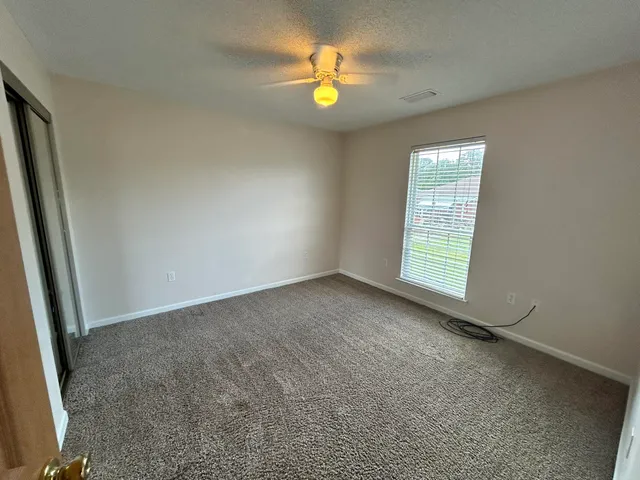 an empty room with window and a fireplace