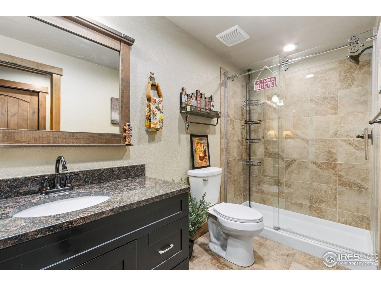 7982 Rising Sun Court Windsor, CO 80550 - Photo 33 of 48 a bathroom with a granite countertop sink toilet a mirror and shower