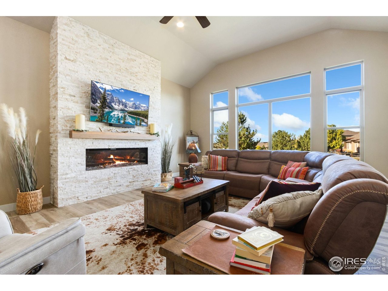 7982 Rising Sun Court Windsor, CO 80550 - Photo 8 of 48 a living room with furniture a flat screen tv and a fireplace