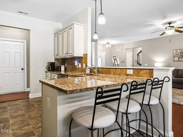 a kitchen with a table chairs and cabinets