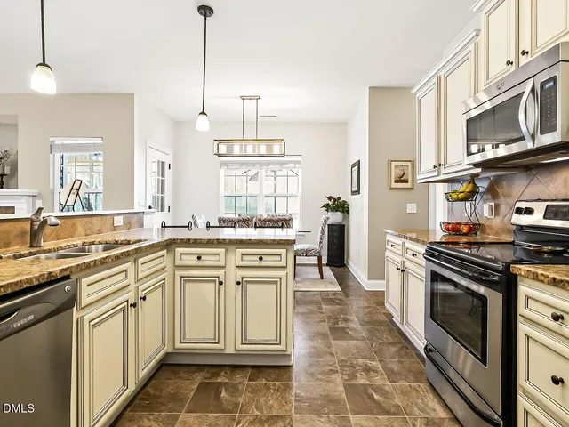 a kitchen with stainless steel appliances granite countertop a stove a sink and a microwave