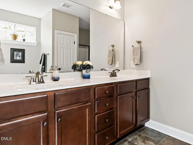 a bathroom with a double vanity sink and a mirror