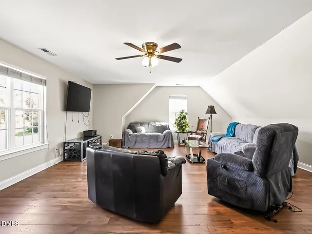 a living room with furniture a flat screen tv and a large window
