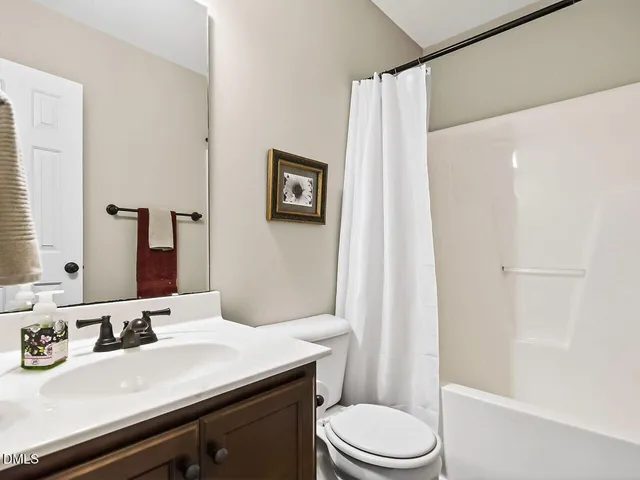 a bathroom with a granite countertop sink toilet a mirror and shower