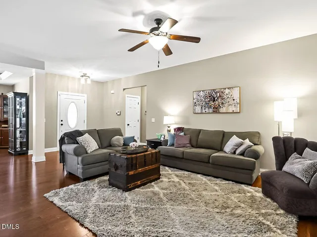 a living room with furniture ceiling fan and a rug