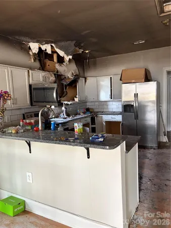 a kitchen with stainless steel appliances granite countertop a sink and a refrigerator