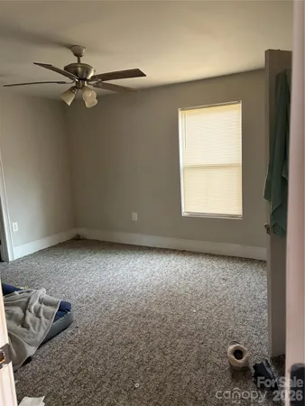 a view of a livingroom with wooden floor and a ceiling fan