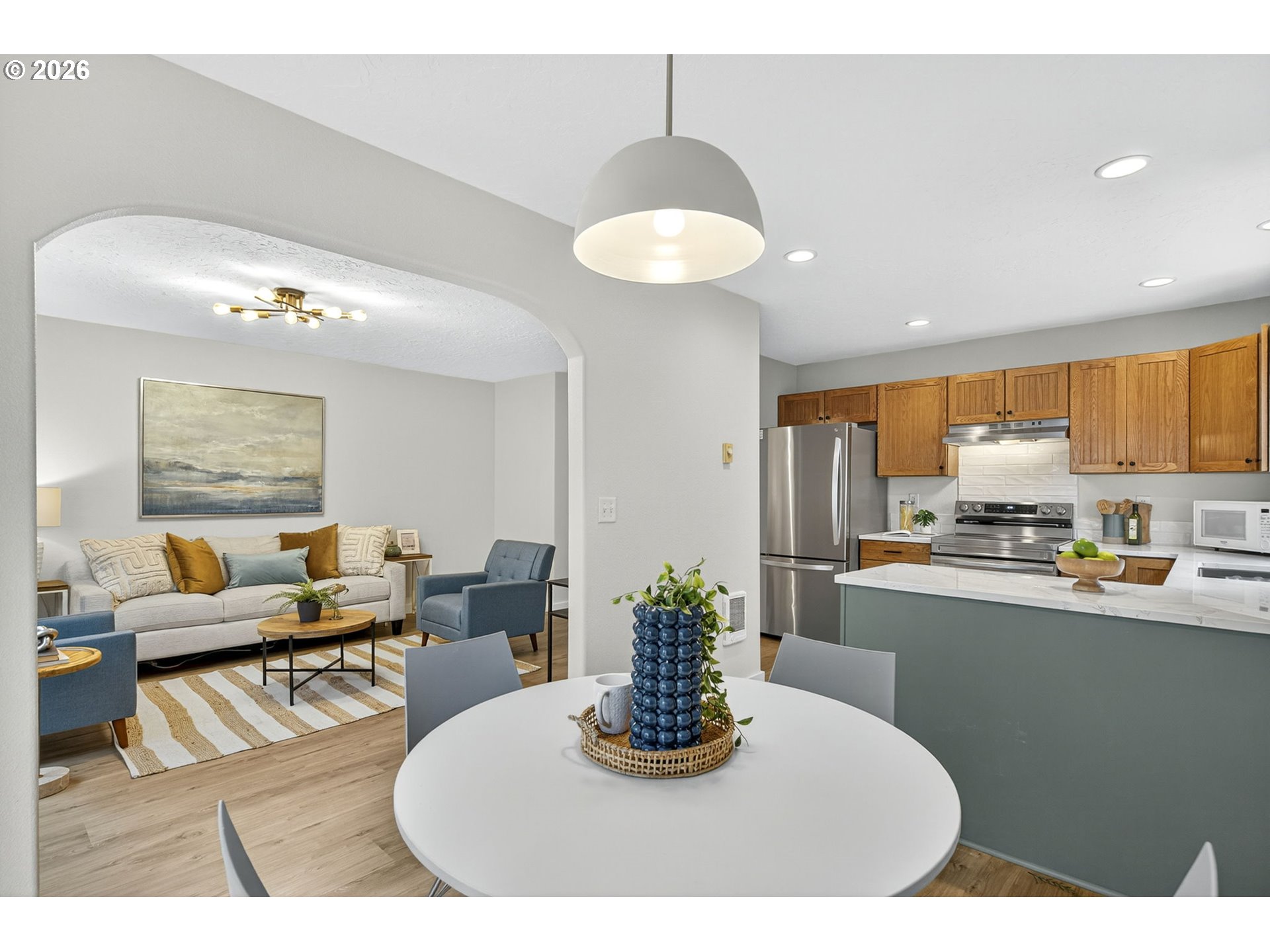 929 Northwest Spring Street Newport, OR 97365 - Photo 20 of 46 a kitchen with stainless steel appliances granite countertop a refrigerator a sink a stove a dining table and chairs with wooden floor