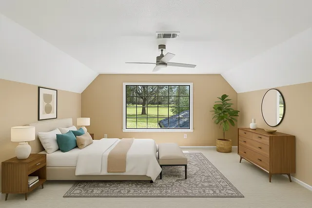 a living room with furniture a large window and a potted plant