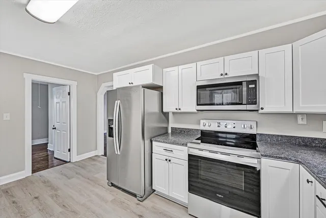 a kitchen with white cabinets and stainless steel appliances