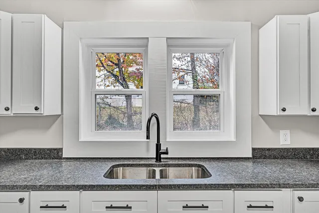 a kitchen with granite countertop a sink and a window