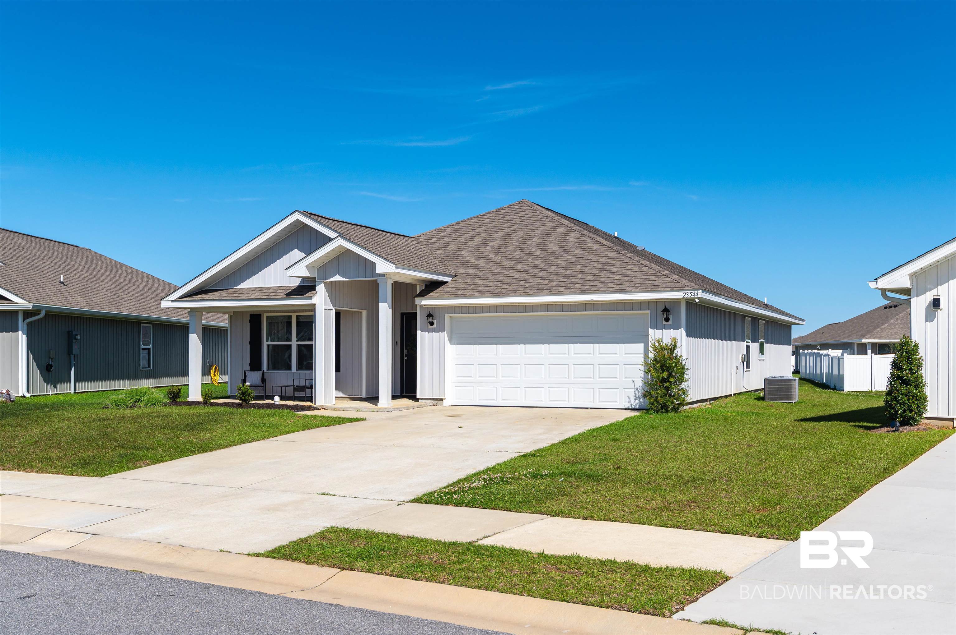 23544 Unbridled Loop Daphne, AL 36526 - Photo 24 of 25 Single-story residence featuring light gray siding, a covered front porch, and an attached two-car garage