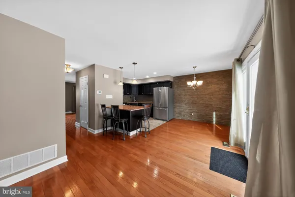 a view of a big room with wooden floor furniture and windows