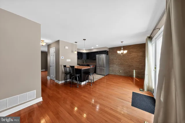 a view of a big room with wooden floor furniture and windows