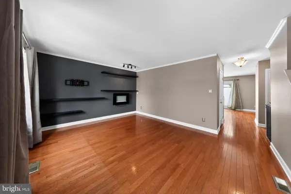 a view of empty room with wooden floor