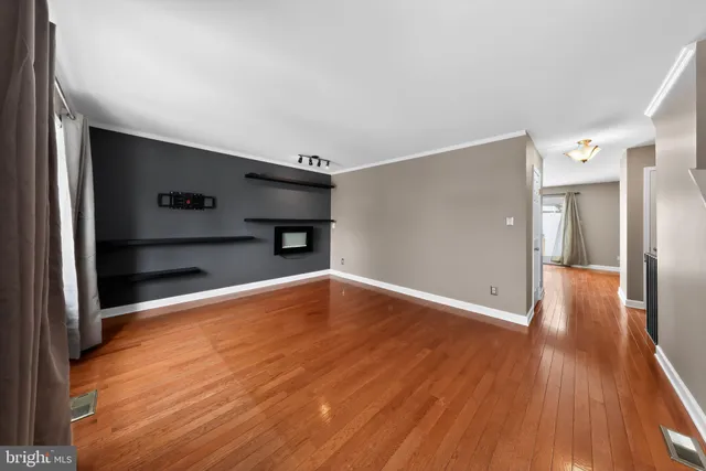 a view of empty room with wooden floor