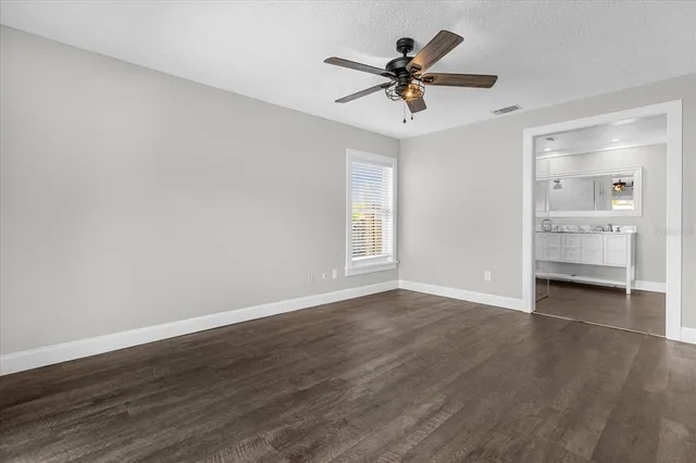 a view of a livingroom with a ceiling fan wooden floor and window