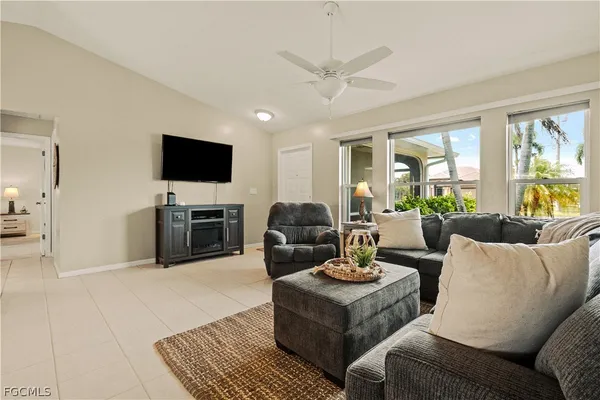 a living room with furniture a flat screen tv and a large window
