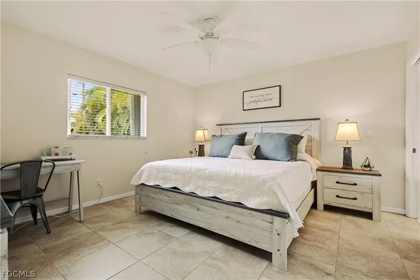 a bedroom with a bed a chair and a chandelier