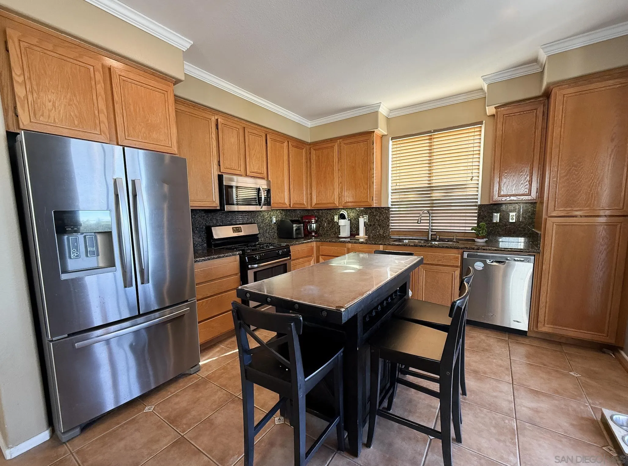 700 Rocking Horse Drive Chula Vista, CA 91914 - Photo 16 of 25 a kitchen with stainless steel appliances a refrigerator a stove a sink a dining table and chairs