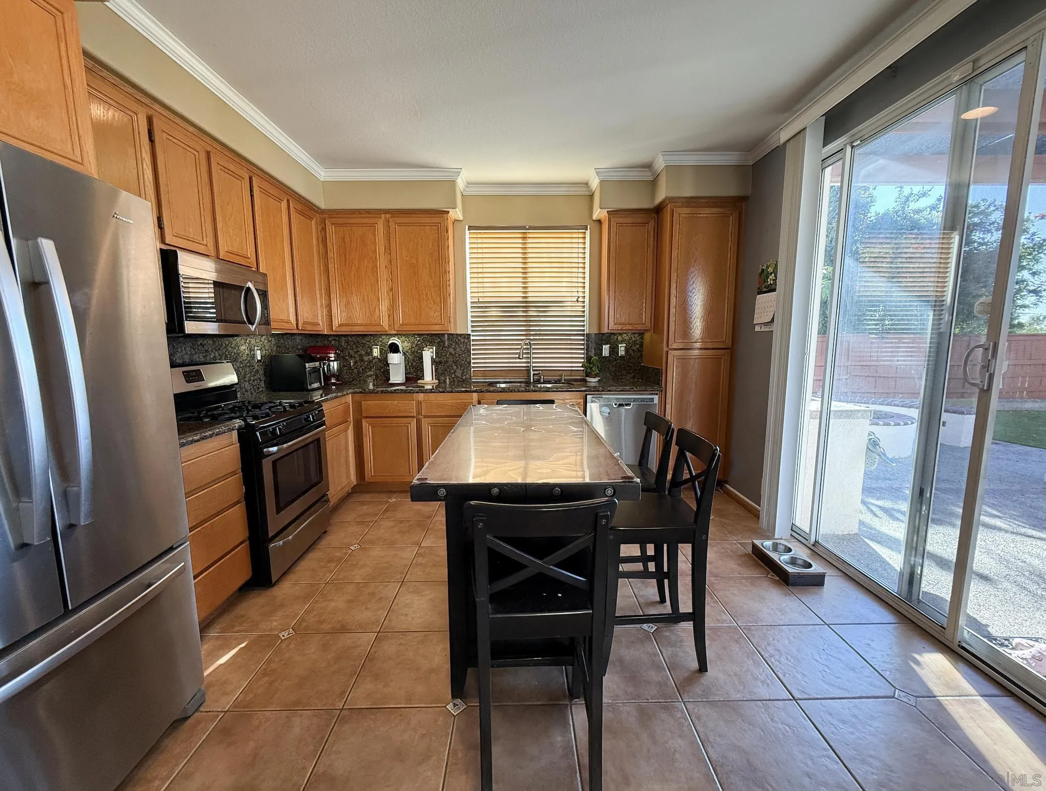 700 Rocking Horse Drive Chula Vista, CA 91914 - Photo 17 of 25 a kitchen with a refrigerator a stove a sink dishwasher a dining table and chairs with wooden floor
