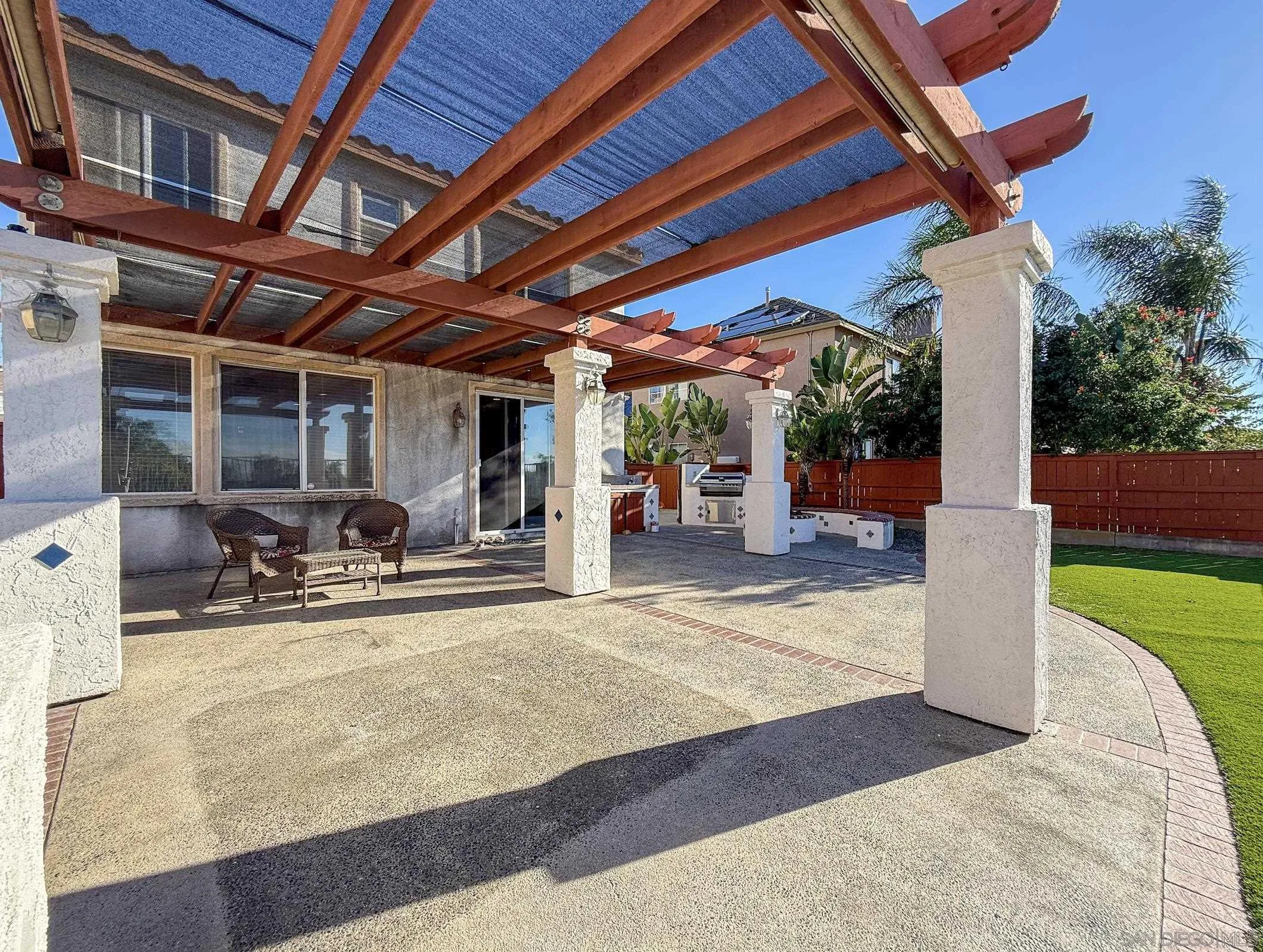 700 Rocking Horse Drive Chula Vista, CA 91914 - Photo 6 of 25 a view of a patio with table and chairs under an umbrella with a barbeque